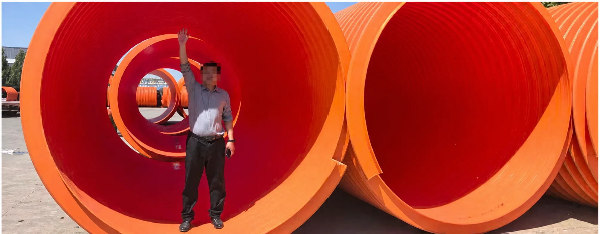 Human scale reference beside a large orange pipe